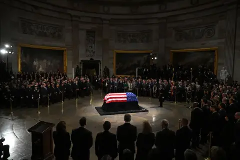 Saul Loeb/AFP A US flag drapes over the coffin of US President Jimmy Carter in the Capitol Rotunda in Washington DC