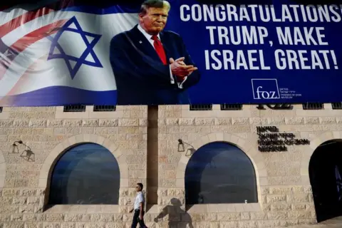 EPA A man walks past a large billboard congratulating US President-elect Donald Trump in front of the Friends of Zion Museum in Jerusalem, November 07, 2024.