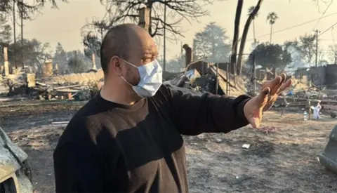 Larry shows his ruined house