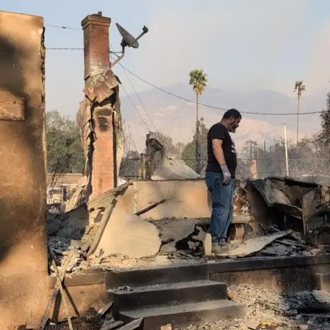 BBC Hipolito Cisneros examines the charred remains of his home after the Eaton fire in California. 