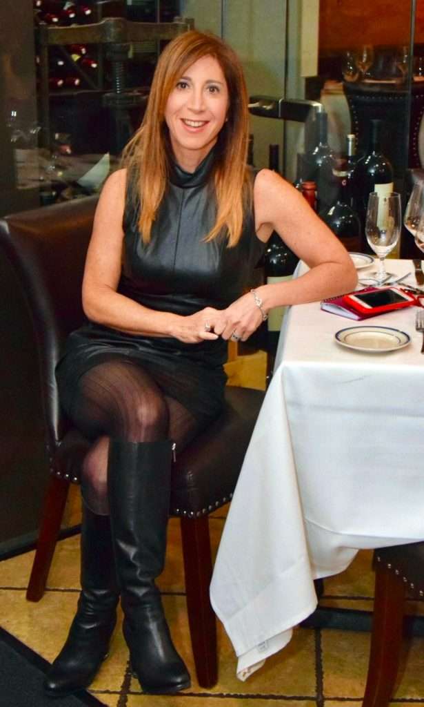 Woman in black outfit seating at restaurant table